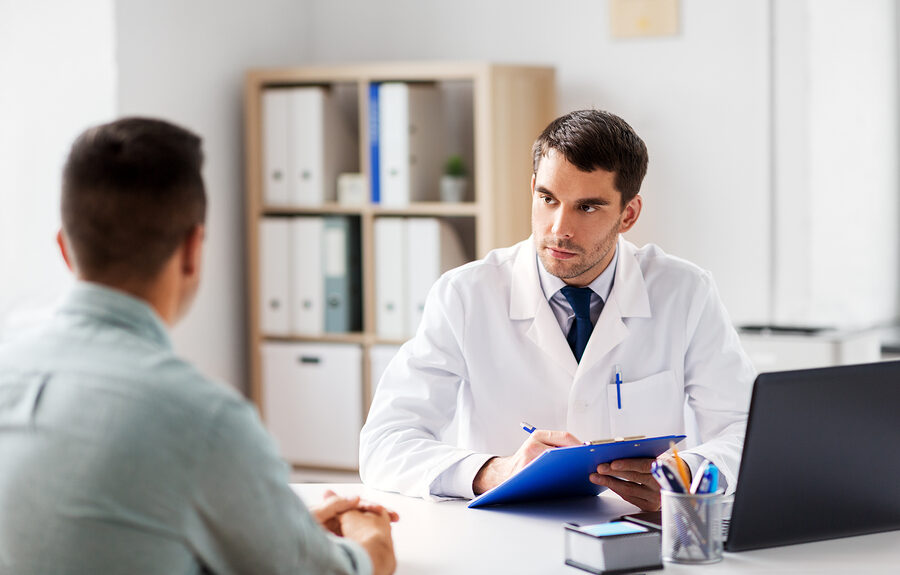 Médico urologista atendendo paciente durante consulta para identificar sinais de alerta.